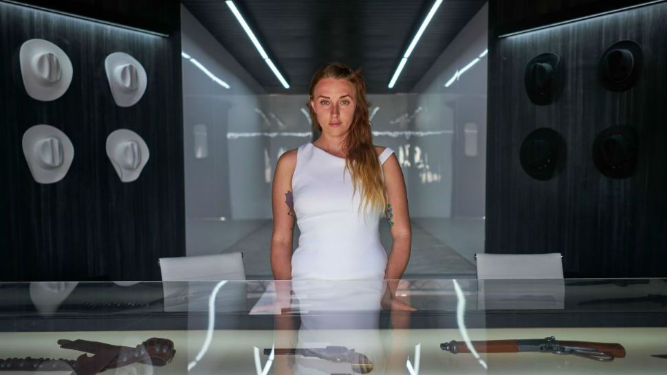 The Delos Portal host greets you behind a glass case of deadly weapons. Image/HBO