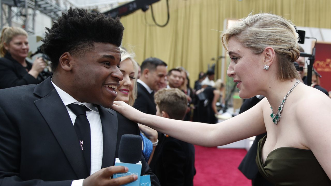 FILE - In this Feb. 9, 2020 file photo, Greta Gerwig, right, talks to Jerry Harris on the red carpet at the Oscars at the Dolby Theatre in Los Angeles. Harris, the star of the Netflix documentary series “Cheer,” was arrested Thursday, Sept. 17 on child pornography charges. (AP Photo/John Locher File)