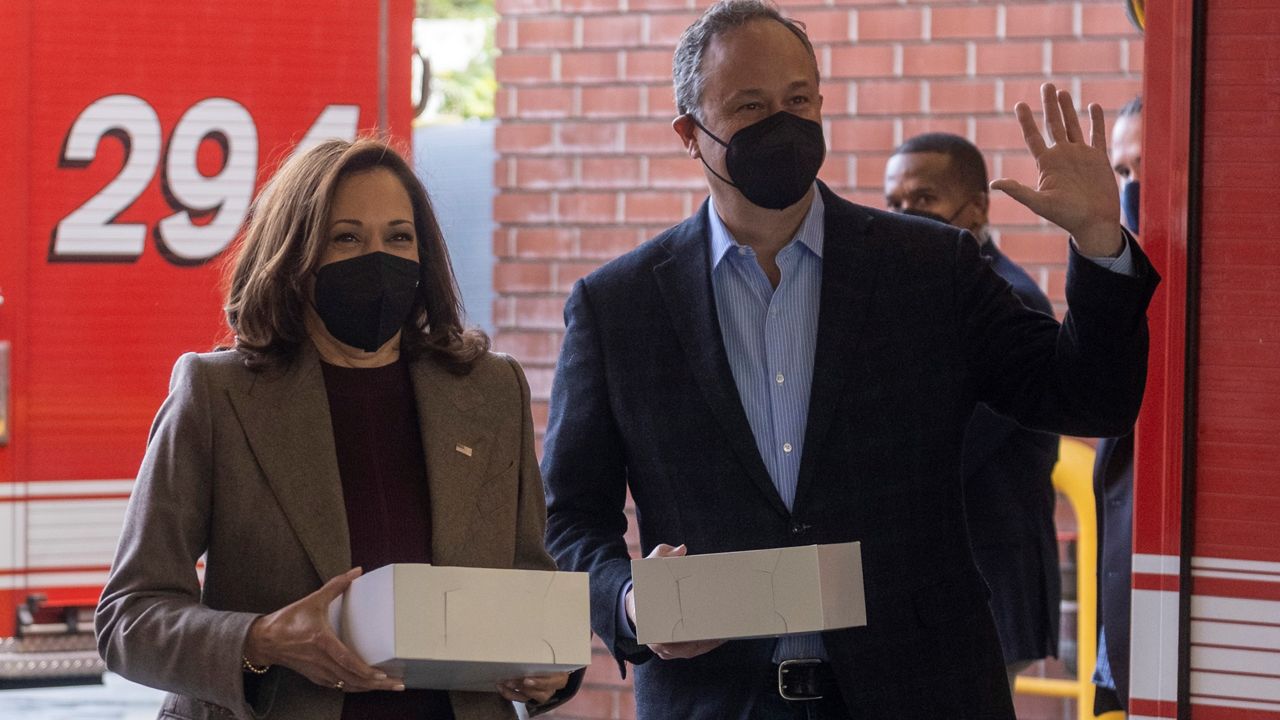 Vice President Kamala Harris, left, wearing a face mask accompanied by second gentleman Douglas Emhoff arrives the Los Angeles Fire Department Station 94, in Los Angeles, Friday, Dec. 24, 2021. (AP Photo/Ringo H.W. Chiu)