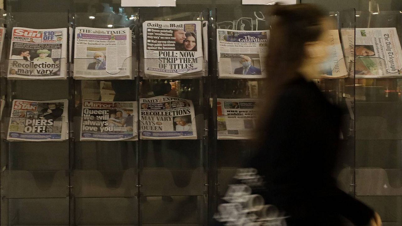 A pedestrian passes newspapers on display outside a shop in London on Wednesday. (AP Photo/Kirsty Wigglesworth)