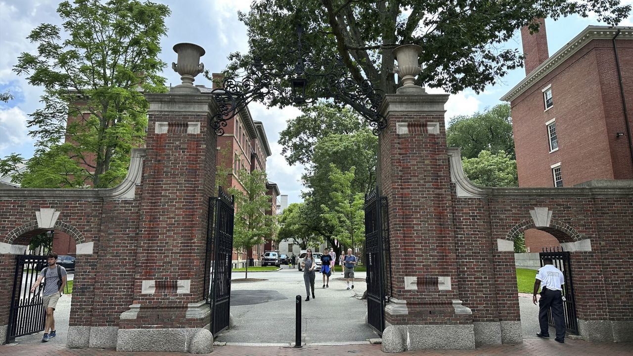 Students walk through a gate Thursday at Harvard University in Cambridge, Mass. (AP Photo/Michael Casey)