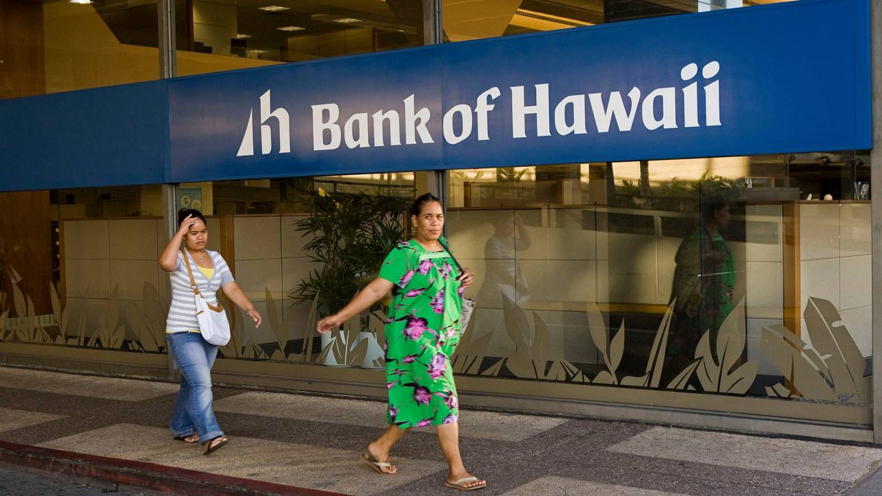 People walk past the Ala Moana branch of Bank of Hawaii in Honolulu. (AP Photo/Marco Garcia)