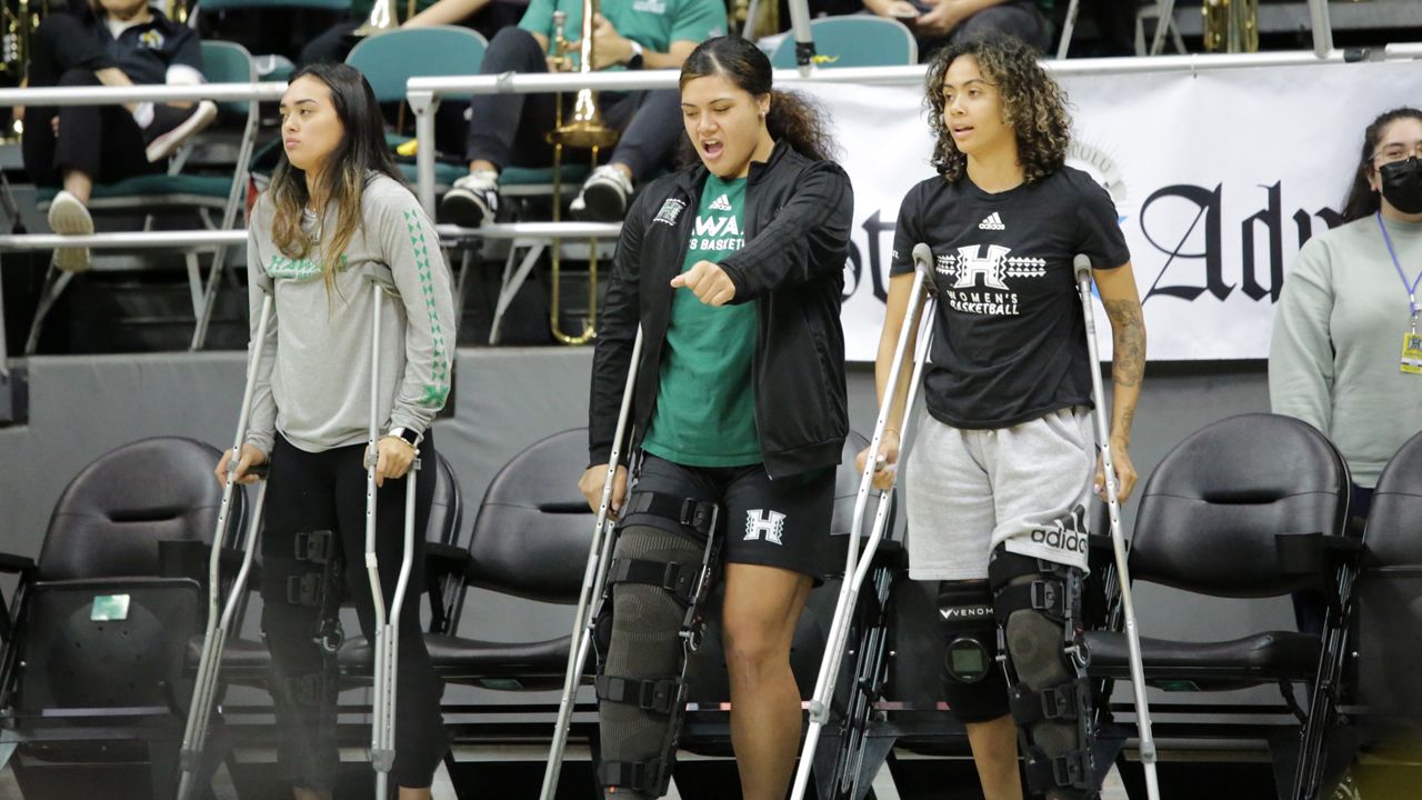 Injured Rainbow Wahine basketball players Jovi Lefotu, Jacque David and Olivia Davies watched their teammates during pregame warmups to face UC Davis. 