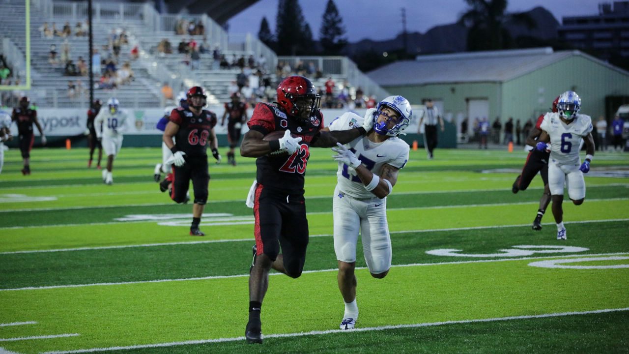 San Diego State running back Kenan Christon stiff-armed Middle Tennessee safety Tra Fluellen in the 2022 EasyPost Hawaii Bowl at the Clarence T.C. Ching Athletics Complex. Middle Tennessee won, 25-23, on a game-winning field goal.