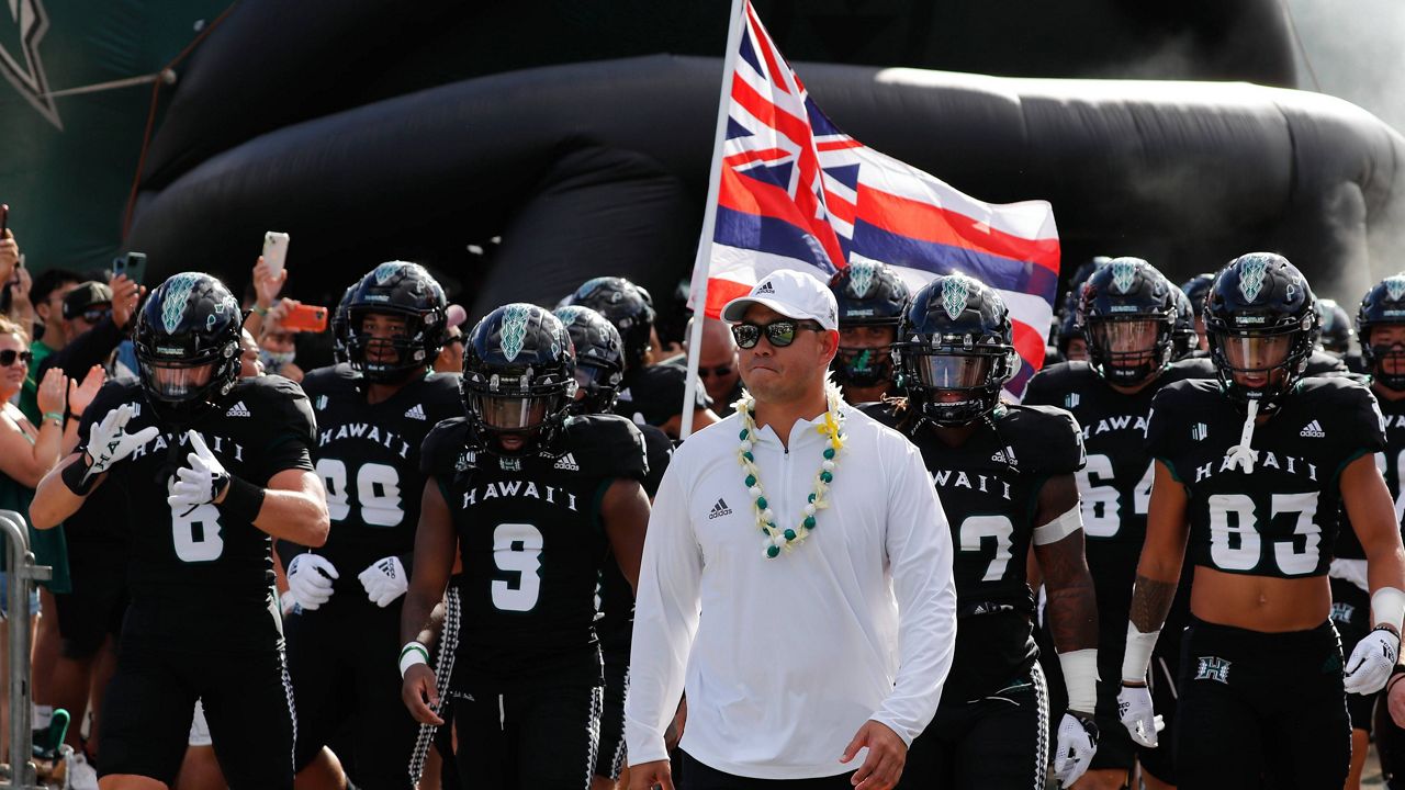 Hawaii head coach Timmy Chang walks out with his team before the start a NCAA college football game against Vanderbilt, Saturday, Aug. 27, 2022, in Honolulu. (AP Photo/Marco Garcia)