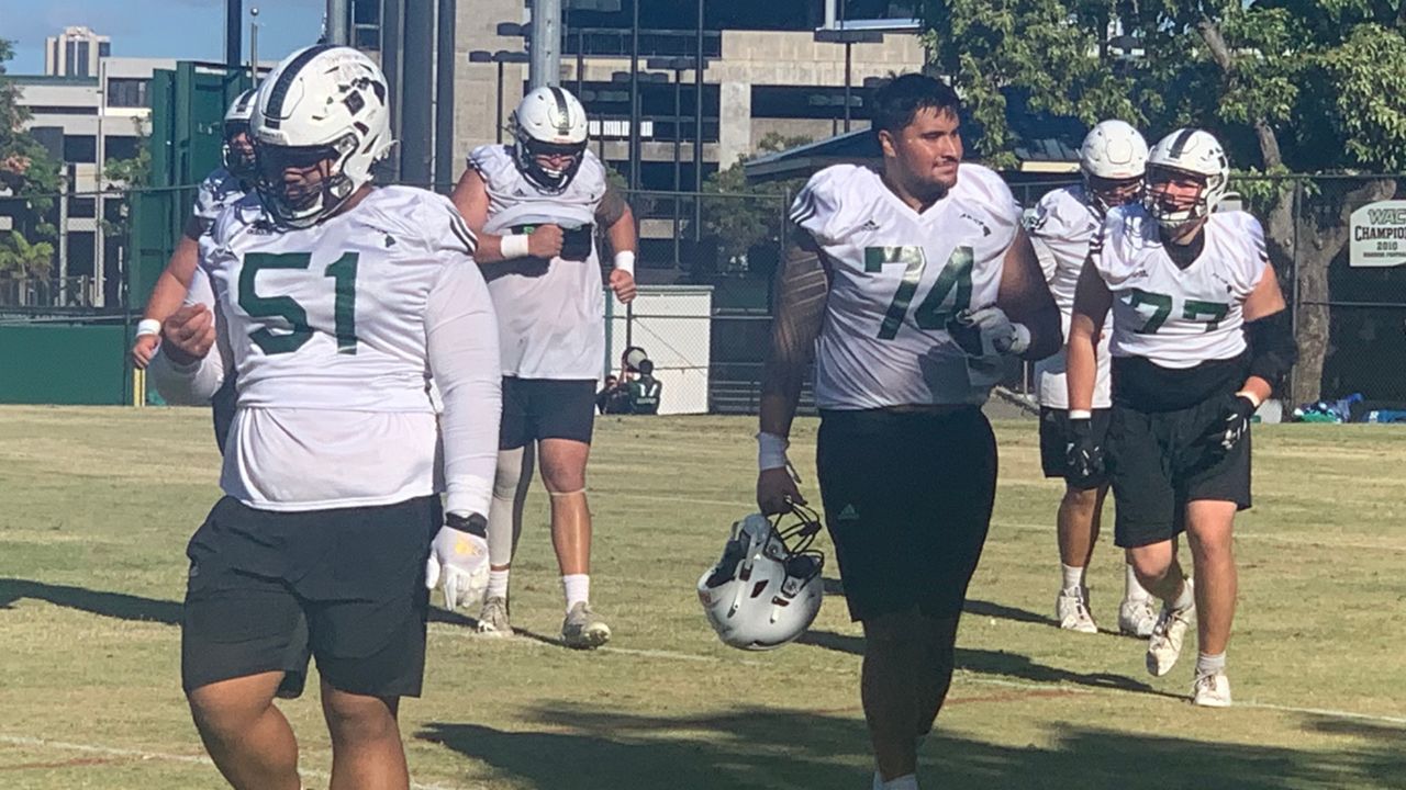 Members of the Hawaii offensive line came off of the grass practice field together after a drill on Thursday.