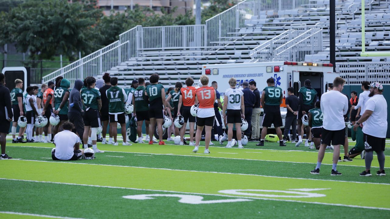 The Hawaii football team gathered around injured Rainbow Warrior safety Kona Moore as an ambulance arrived to collect him at Thursday morning's spring practice at the Clarence T.C. Ching Athletics Complex.
