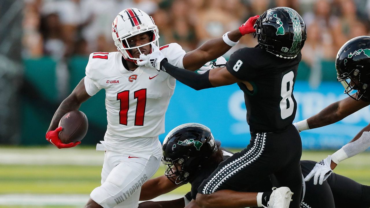 Western Kentucky receiver Malachi Corley fended off Hawaii defensive back JoJo Forest on Saturday night.