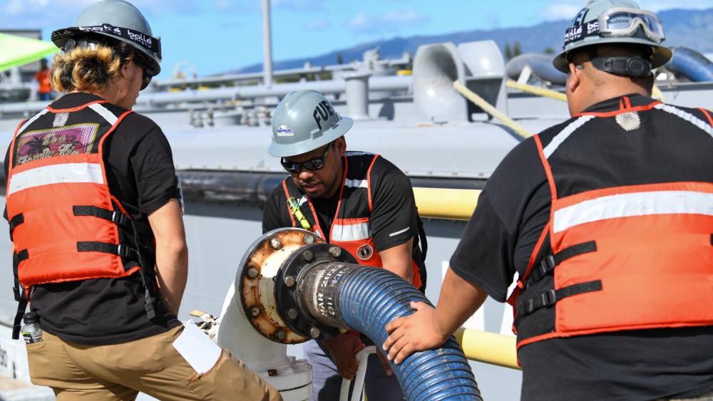 Naval Supply Systems Command Fleet Logistics Center Pearl Harbor fuel distribution system workers turn a valve to begin unpacking F76 marine diesel fuel. (Photo courtesy of U.S. Navy) 
