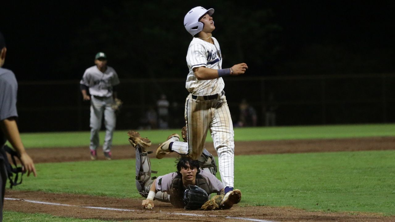 Kamehameha baseball's Jace Souza got caught in a rundown between third base and home plate by Mid-Pacific catcher Noah Kubo in a 4-2 Warriors win at Central Oahu Regional Park last Thursday.