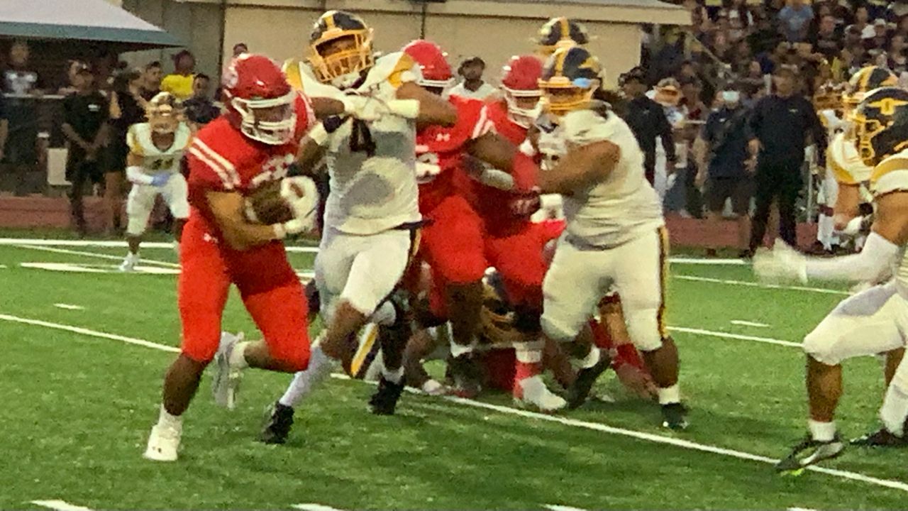 Kahuku running back Clyde Taulapapa looked for a hole against the Punahou defense in the first quarter Saturday.