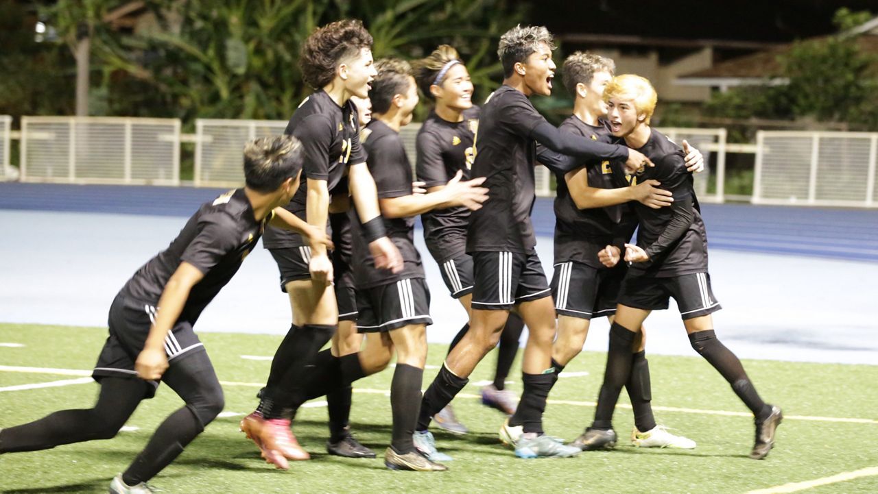 Mililani players mobbed Ethan Funtanilla (19), right, after his rebound header goal gave the Trojans a two-goal lead in the 64th minute Saturday.