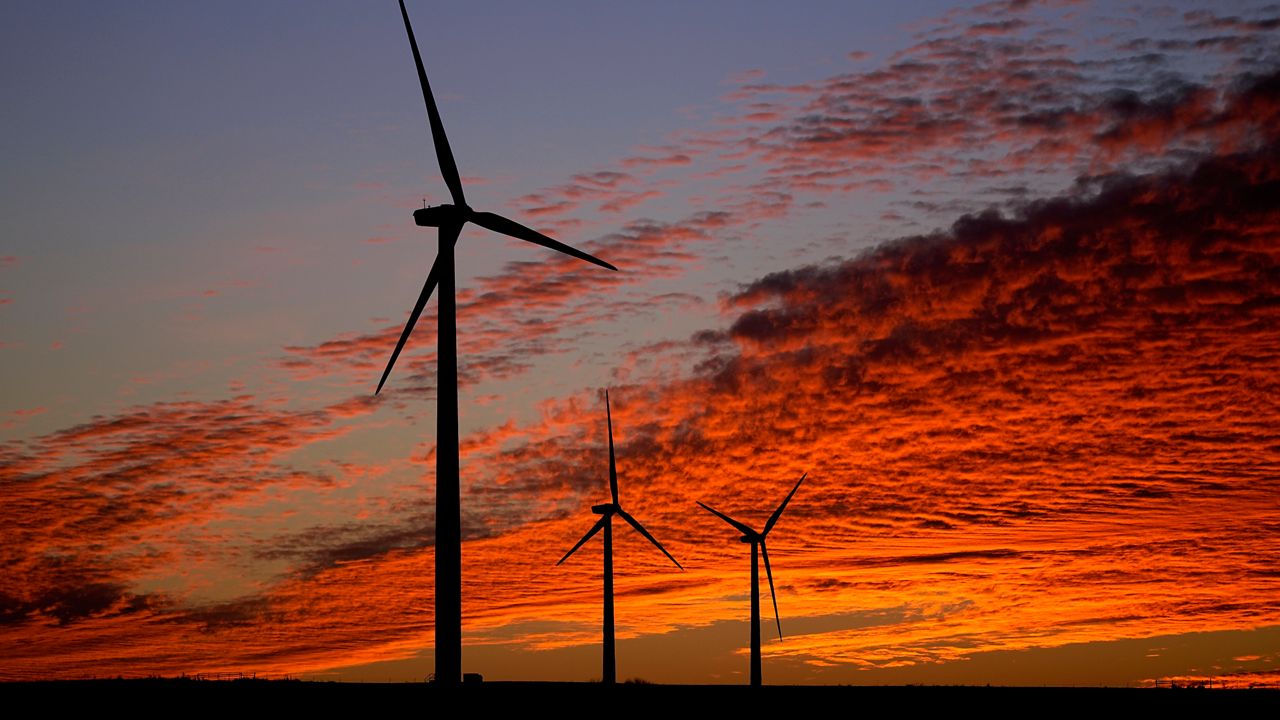 Wind turbines are silhouetted against the sky at sunset Friday, Dec. 17, 2021, near Ellsworth, Kan. The 300-foot-tall turbines are among the 134 units comprising the Post Rock Wind Farm. (AP Photo/Charlie Riedel)