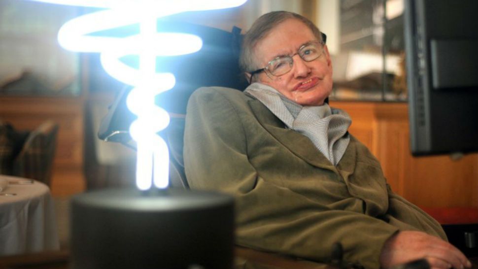 In this Feb. 25, 2012 photo, Professor Stephen Hawking poses beside a lamp titled ‘black hole light’ by inventor Mark Champkins, presented to him during his visit to the Science Museum in London. Hawking, whose brilliant mind ranged across time and space though his body was paralyzed by disease, died early Wednesday, March 18, 2018, a University of Cambridge spokesman said. He was 76. (Anthony Devlin/PA via AP)