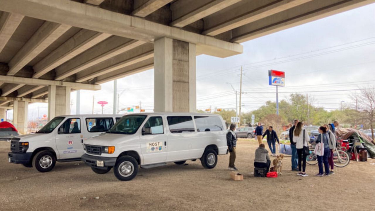 Vans are in place to transfer people at a homeless encampment to temporary shelter. (City of Austin) 