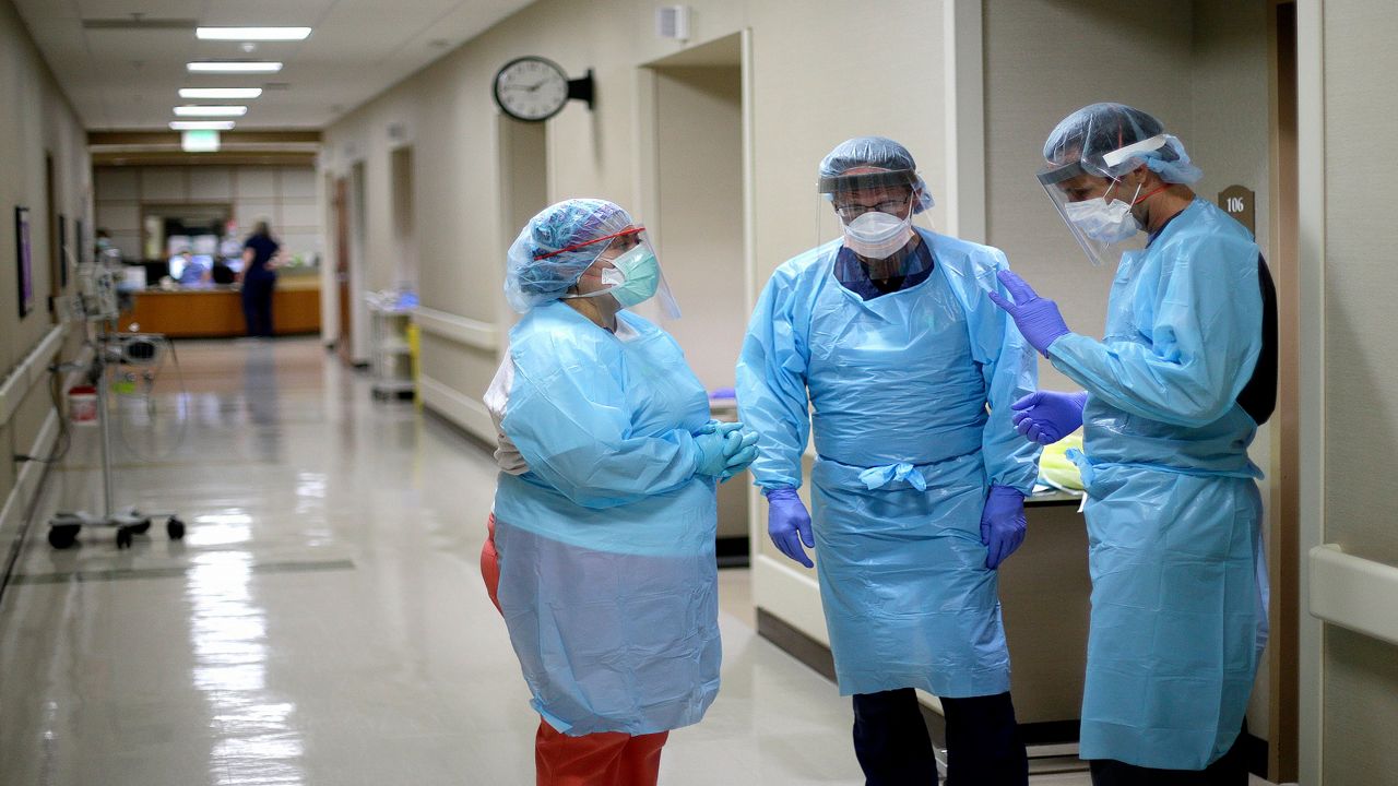 Health care workers dressed in PPE stand in a hospital (Spectrum News/File)