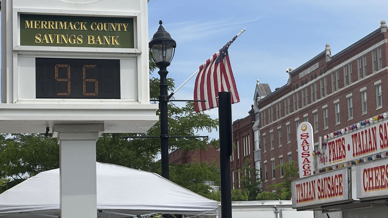A bank clock overlooking the Market Days street fair in Concord, N.H., shows the temperature Thursday morning, June 20, 2024. A heat wave moved closer to a breaking point Thursday, with millions of people sweating it out for another day. (AP Photo/Kathy McCormack)