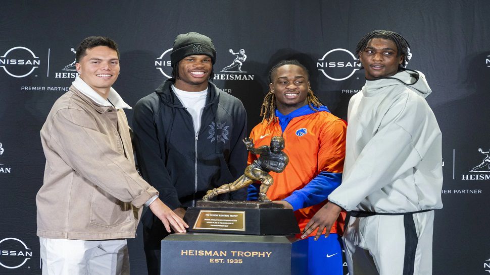 Heisman Trophy finalists, from left, Oregon's Dillon Gabriel, Colorado's Travis Hunter, Boise State's Ashton Jeanty and Miami's Cam Ward pose with the trophy during a college football media availability, Friday, Dec. 13, 2024, in New York. (AP Photo/Corey Sipkin)