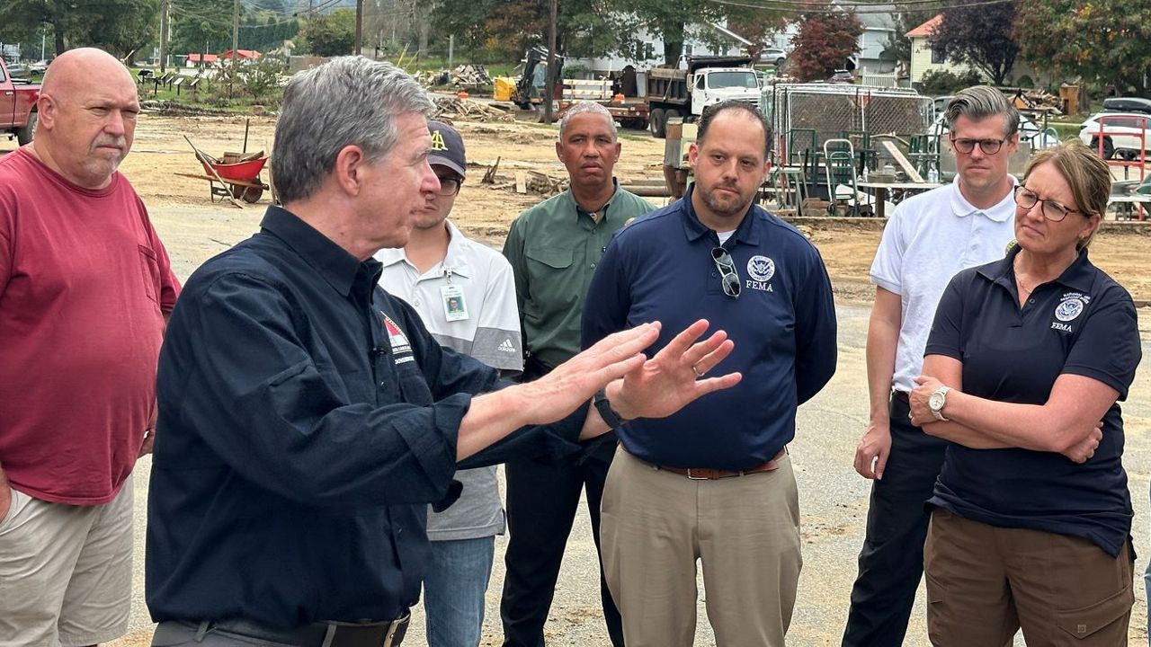 Gov. Roy Cooper, second from left, visits Canton, in Haywood County in western North Carolina, on Oct. 4, 2024, to survey damage caused by Hurricane Helene. (Spectrum News 1/Estephany Escobar)