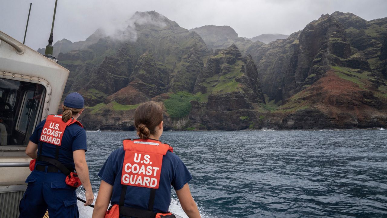 In this photo provided by the U.S. Coast Guard, coast guardsmen participate in a search after a helicopter crash near Na Pali Coast, Kauai, Hawaii. The tour company aircraft went down off the Hawaiian island of Kauai, police said, in the latest in a series of crashes to plague the industry in recent years. (Ty Robertson/USCG via AP)