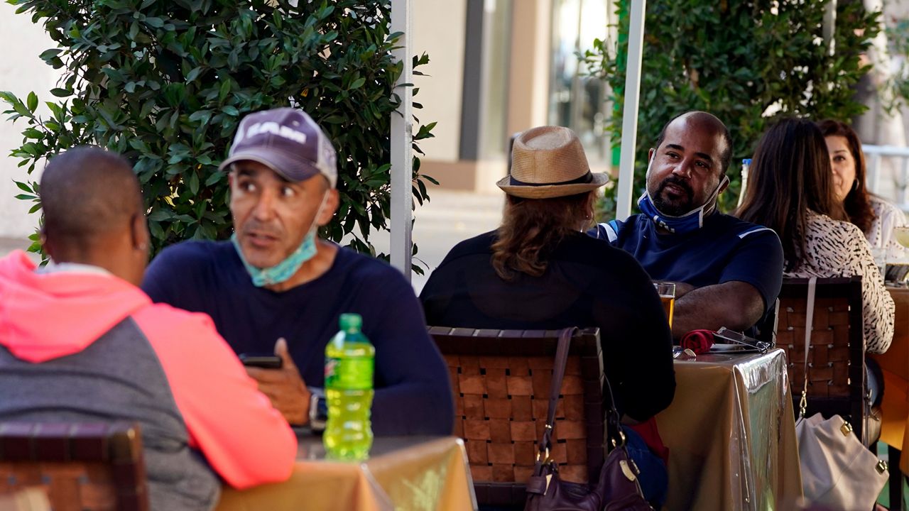 People eat lunch outdoors Tuesday, Dec. 1, 2020, in Pasadena, Calif.  (AP Photo/Marcio Jose Sanchez)