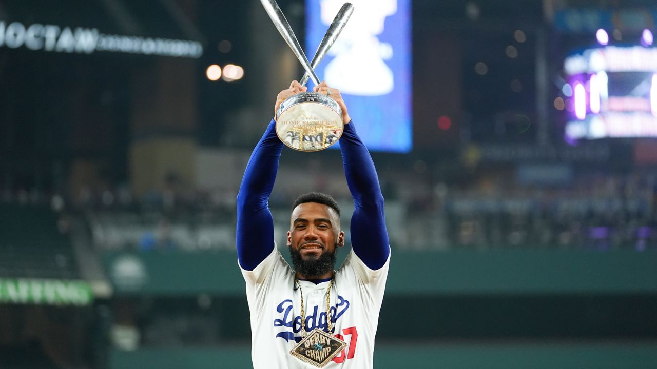 National League's Teoscar Hernández, of the Los Angeles Dodgers, poses for photos with the winner's trophy after the MLB baseball All-Star Home Run Derby Monday in Arlington, Texas. (AP Photo/Julio Cortez)