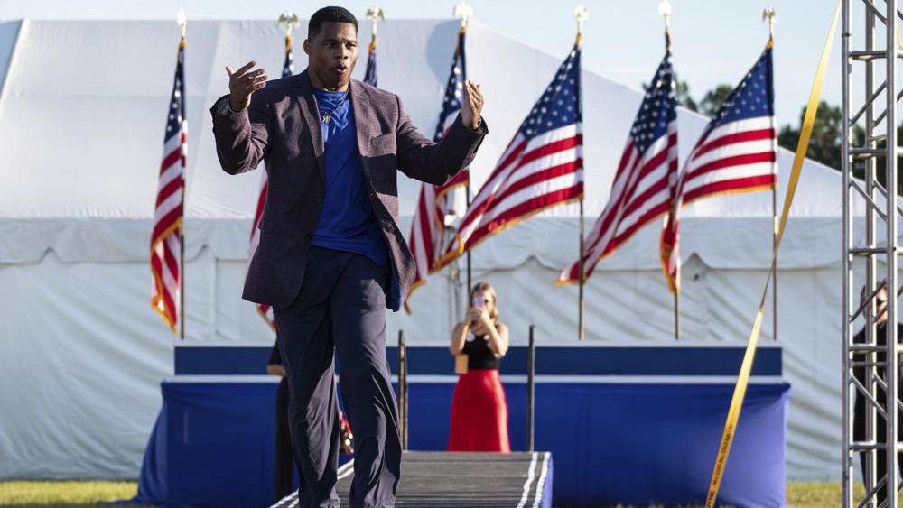FILE - Senate candidate Herschel Walker takes the stage during former president Donald Trump's Save America rally in Perry, Ga., on Saturday, Sept. 25, 2021. Walker canceled a planned Texas fundraiser on Wednesday, Oct. 13 because an organizer was displaying a swastika made from syringes on social medial to protest mandatory vaccination. (AP Photo/Ben Gray, File)