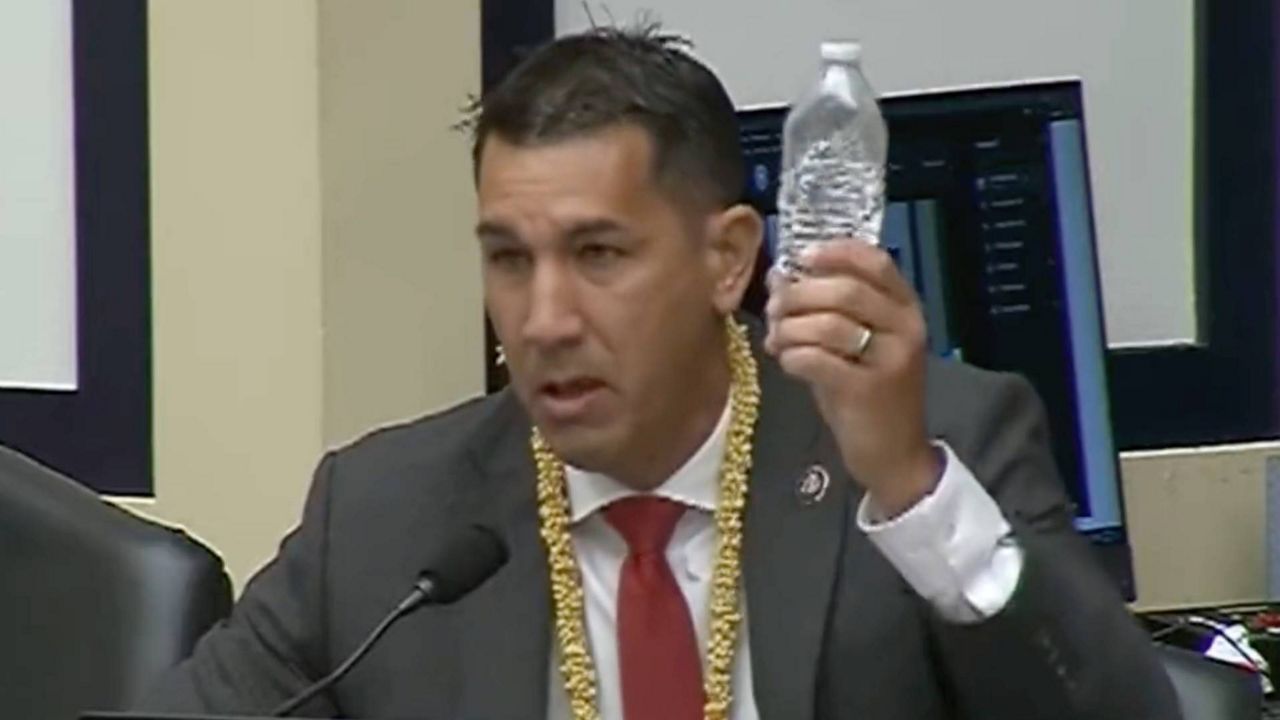 Rep. Kai Kahele holds up a bottle filled with water he collected from a residence at Joint Base Pearl Harbor-Hickam's Navy housing during a hearing of the House Armed Services Committee (Courtesy Rep. Kai Kahele via Twitter)