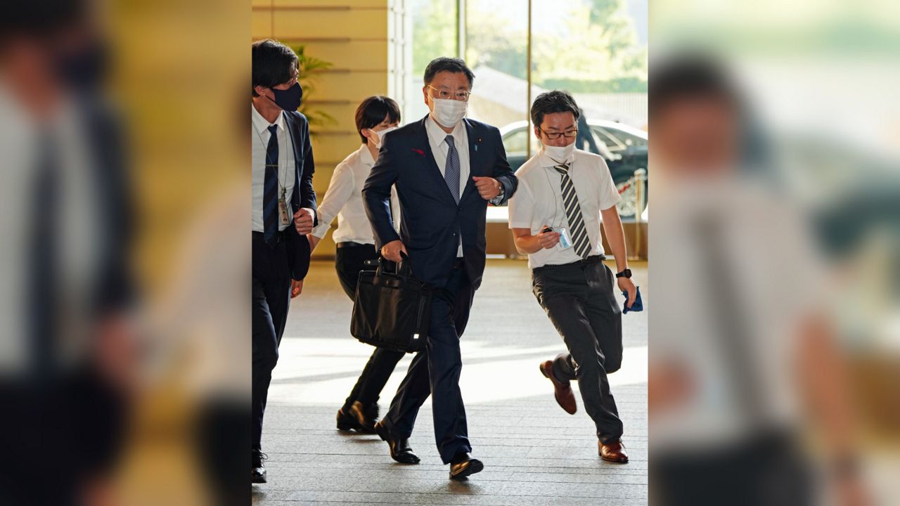Japan's Chief Cabinet Secretary Hirokazu Matsuno, center, arrives at the prime minister's office in Tokyo Tuesday, Oct. 4, 2022. South Korea says North Korea has fired a ballistic missile toward its eastern waters. (Kyodo News via AP)