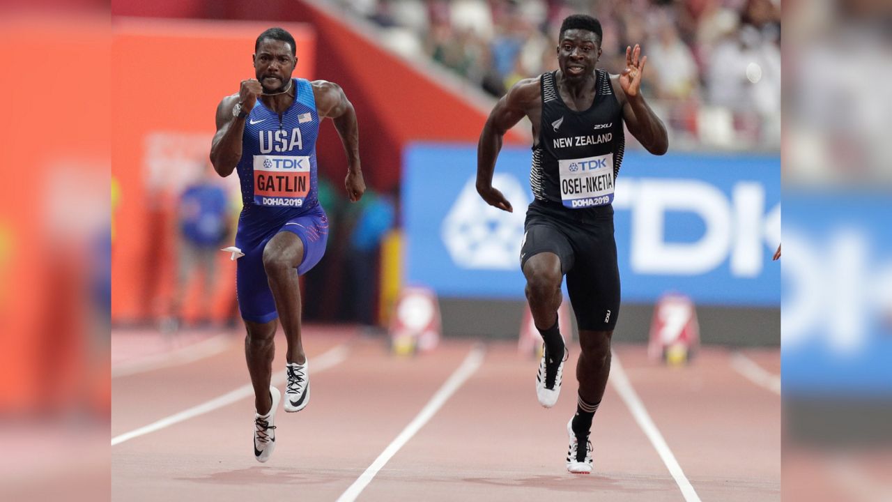 New Zealand's Edward Osei-Nketia, right, and Justin Gatlin of the United States compete during the men's 100 meters heat at the World Athletics Championships in Doha, Qatar, Sept. 27, 2019. The fastest man in New Zealand is ready to try college football. He has signed to play for Hawaii and is among a geographically diverse group of international recruits who will suit up on campuses across the United States. (AP Photo/Petr David Josek, File)
