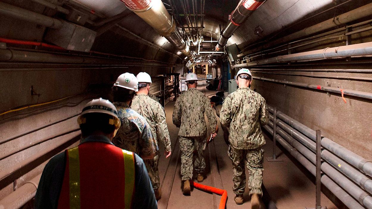 In this file photo provided by the U.S. Navy, Rear Adm. John Korka, Commander, Naval Facilities Engineering Systems Command, and Chief of Civil Engineers, leads Navy and civilian water quality recovery experts through the tunnels of the Red Hill Bulk Fuel Storage Facility, near Pearl Harbor, Hawaii, on Dec. 23, 2021. (Mass Communication Specialist 1st Class Luke McCall/U.S. Navy via AP)