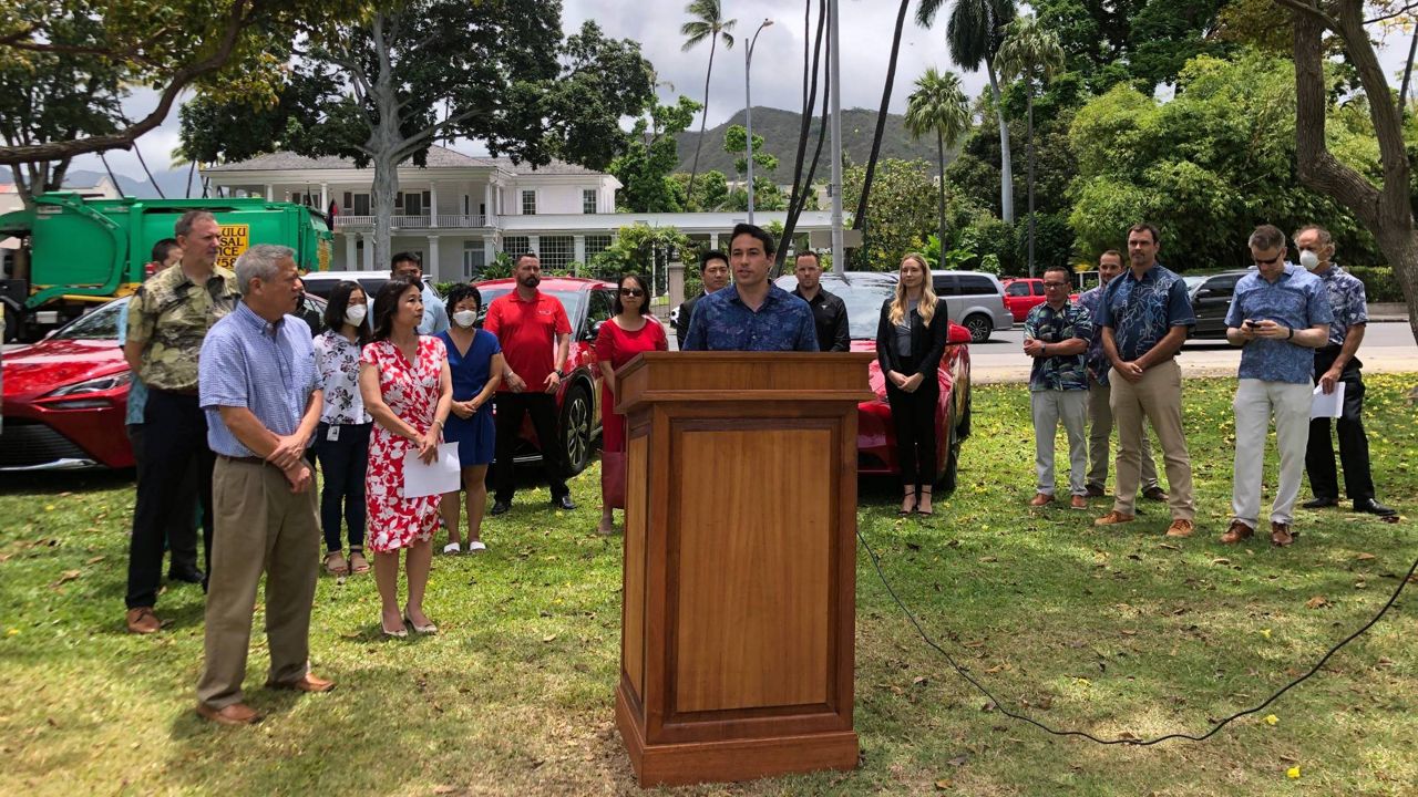 Hawaii State Sen. Chris Lee, center, speaks at a news conference in Honolulu on Thursday, May 19, 2022. Hawaii lawmakers this year passed legislation creating a working group to develop ways to eliminate greenhouse gas emissions on transportation between the islands. (AP Photo/Audrey McAvoy)