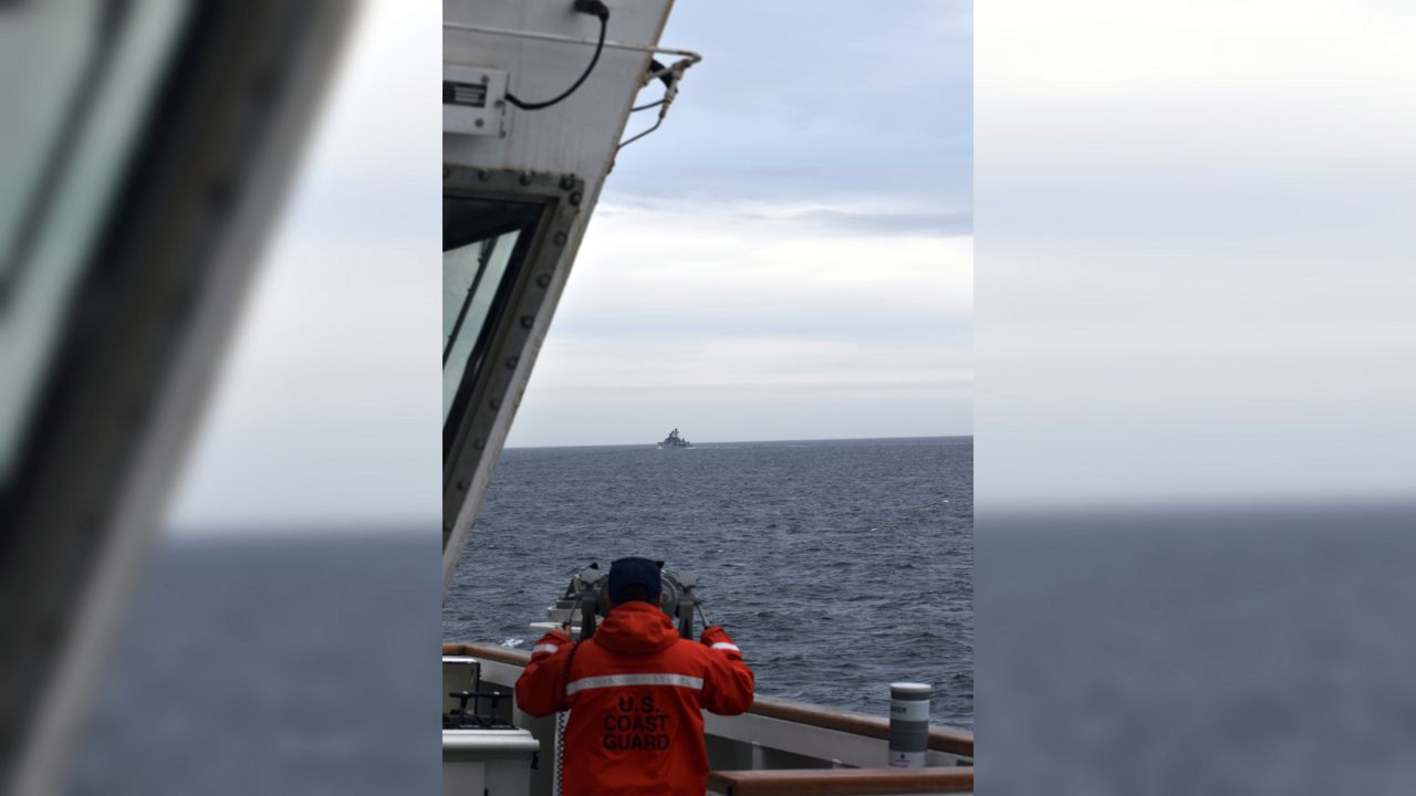 In this photo provided by the U.S. Coast Guard, a Coast Guard Cutter Kimball crew-member observes a foreign vessel in the Bering Sea, Monday, Sept. 19, 2022. The U.S. Coast Guard cutter on routine patrol in the Bering Sea came across the guided missile cruiser from the People's Republic of China, officials said Monday, Sept. 26. (U.S. Coast Guard District 17 via AP)