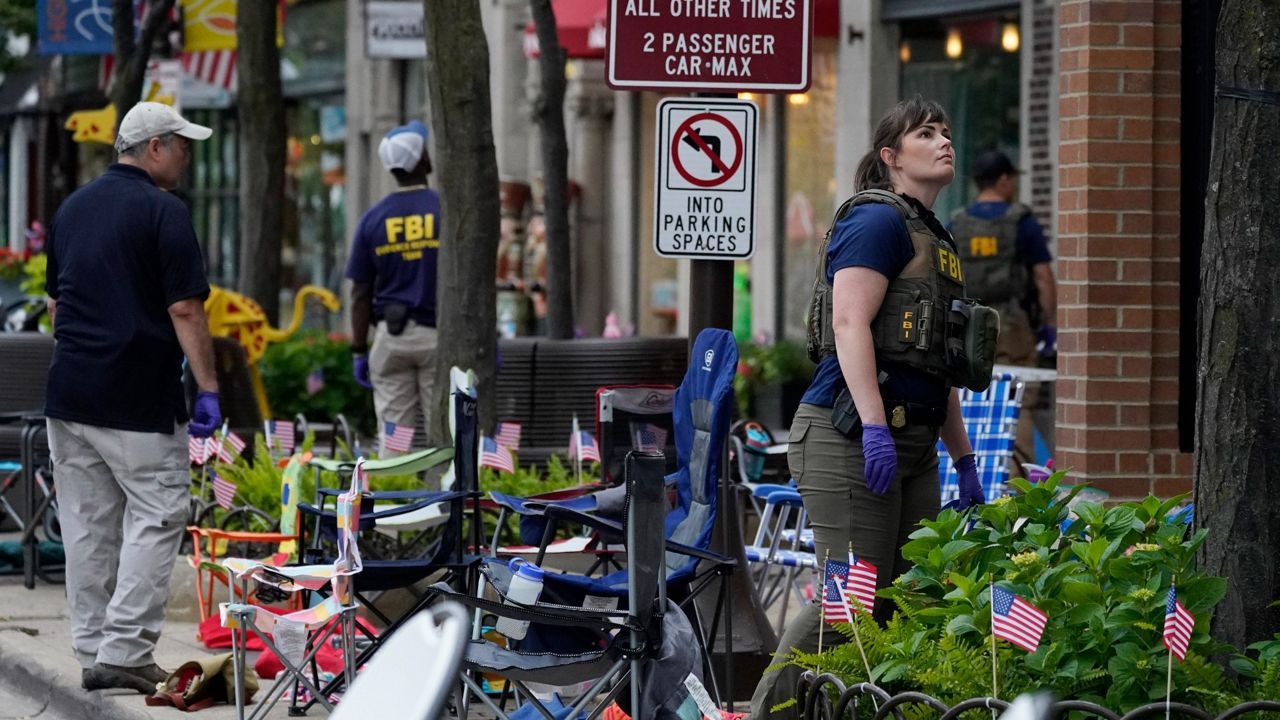Law enforcement conduct a search Monday after a mass shooting at the Highland Park Fourth of July parade in Highland Park, Ill. (AP Photo/Nam Y. Huh)