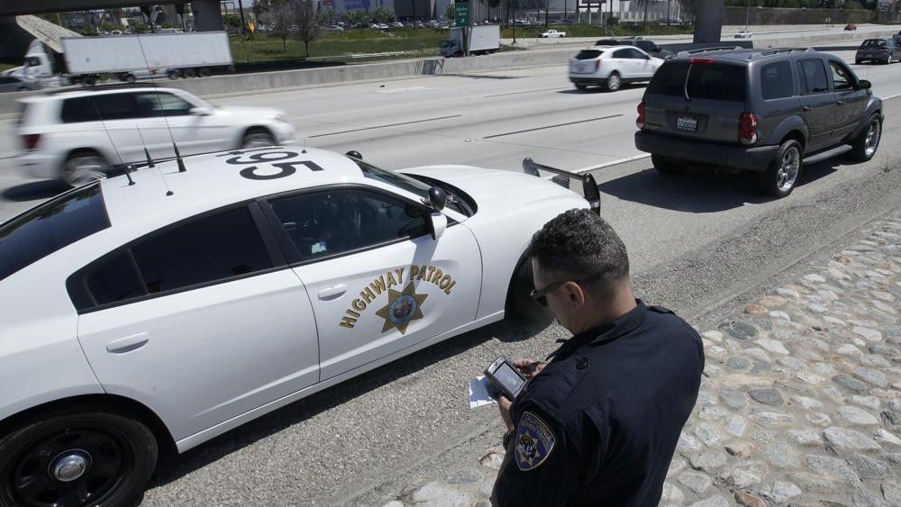 Highway patrol runs a drivers license after stopping a motorist.  (AP Photo/Chris Carlson)