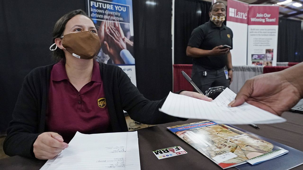 Ariel Jones, a UPS human resources intern, hands an applicant an information sheet Tuesday during the Lee County Area Job Fair in Tupelo, Miss. (AP Photo/Rogelio V. Solis)