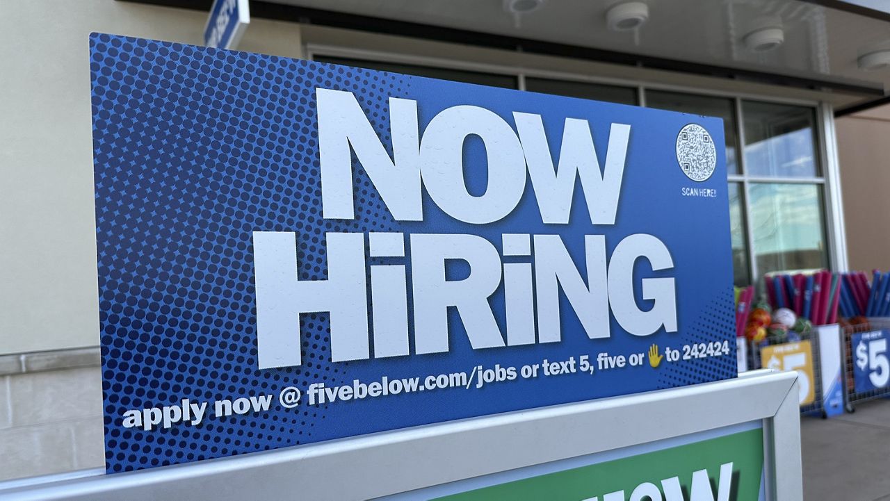 A hiring sign beckons potential employees to apply for work inside a discount store Wednesday, April 3, 2024, in Centennial, Colo. (AP Photo/David Zalubowski)