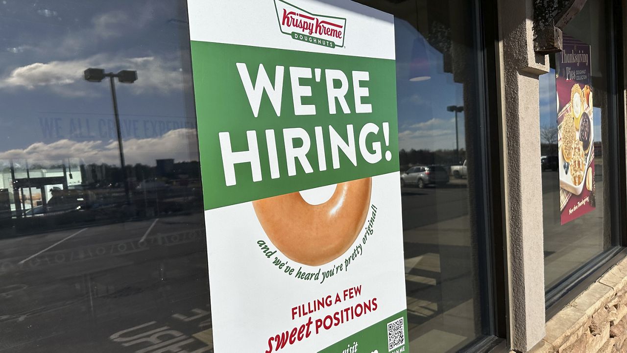 A hiring sign is displayed in the window of a Krispy Kreme donut shop on Nov. 19, 2024, in Lone Tree, Colo. (AP Photo/David Zalubowski, File)