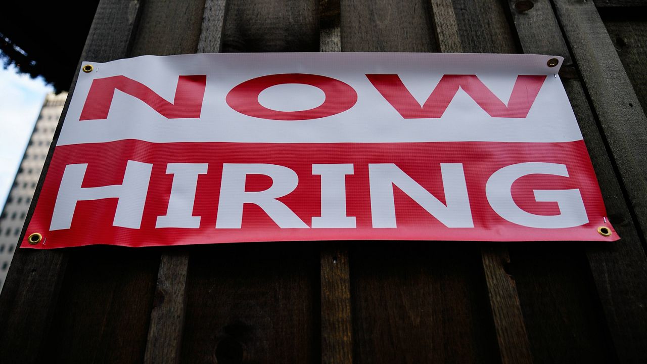 A "NOW HIRING" sign is posted at the Christmas Village at John F. Kennedy Plaza, commonly known as Love Park, in Philadelphia on Nov. 29. (AP Photo/Matt Rourke)