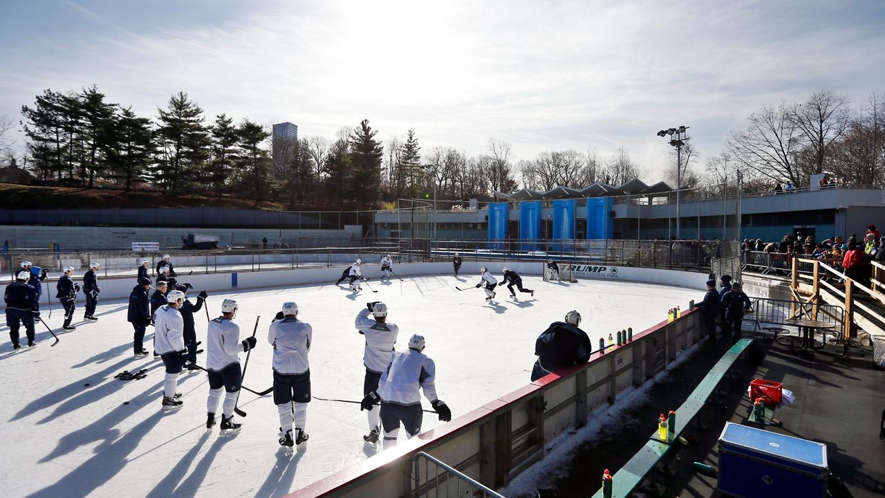 In this Nov. 30, 2013 photo, the Winnipeg Jets, wearing white jerseys, run a drill during an NHL hockey practice at Lasker Rink in New York's Central Park as the sun is shining.