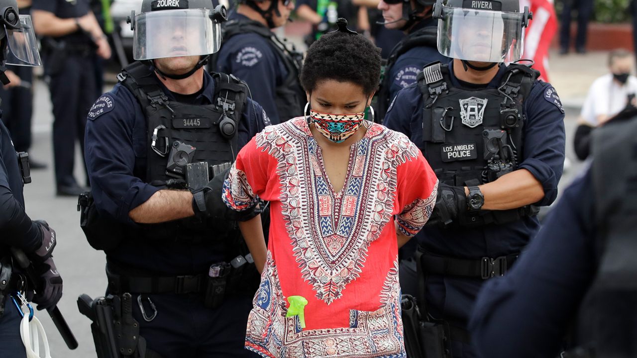 A protester is arrested for violating a curfew Monday, June 1, 2020, in the Hollywood area of Los Angeles during demonstrations over the death of George Floyd. Floyd, a black man, died after being restrained by Minneapolis police officers on May 25. (AP Photo/Marcio Jose Sanchez)