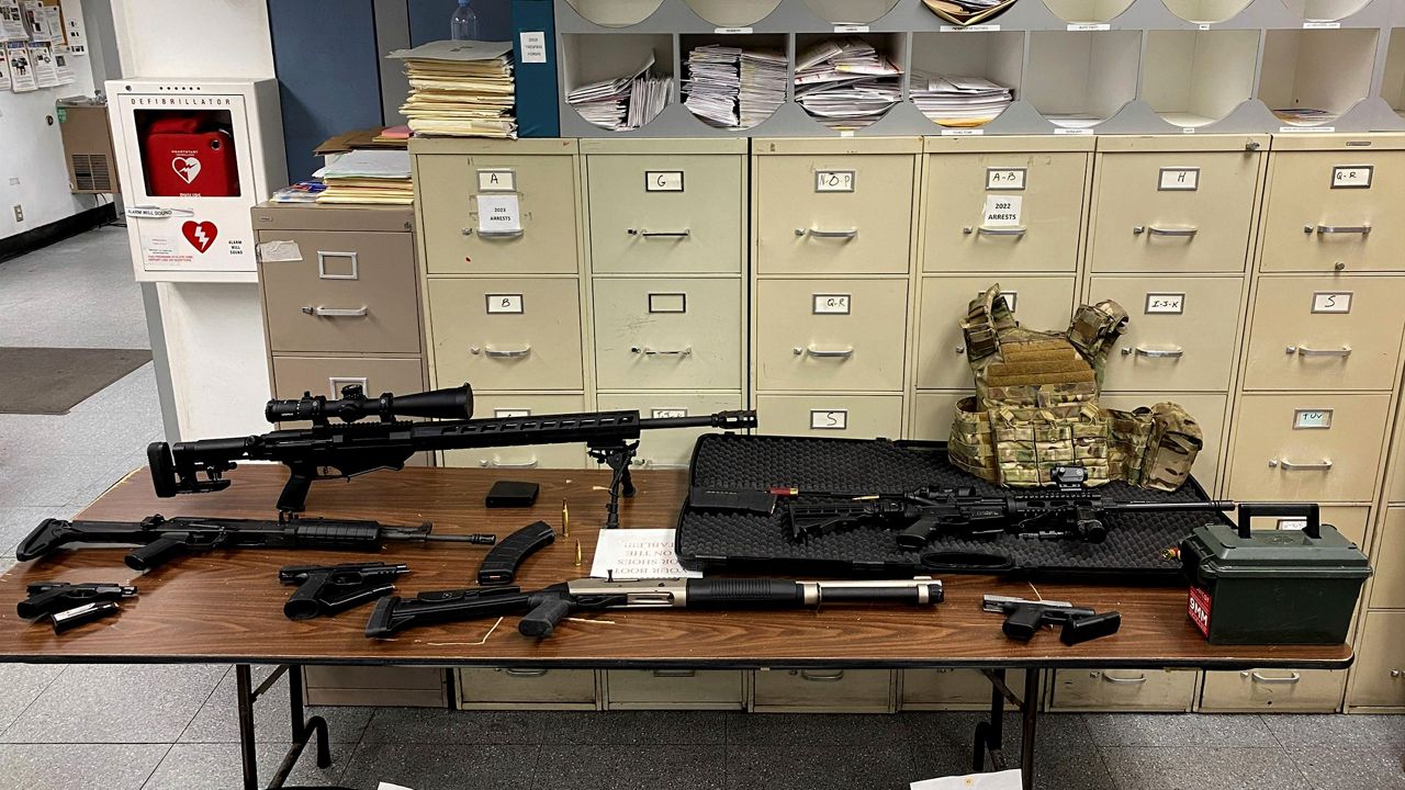 This photo provided by the Los Angeles Police Department shows guns and ammunition that were found in an L.A. apartment. 