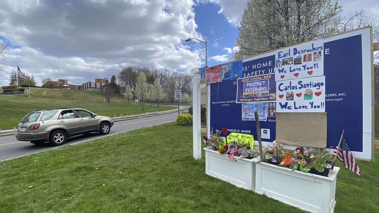 Tributes to veterans cover a sign Tuesday, April 28, 2020, near an entrance road to Soldiers' Home in Holyoke, Mass. (AP Photo/Rodrique Ngowi)