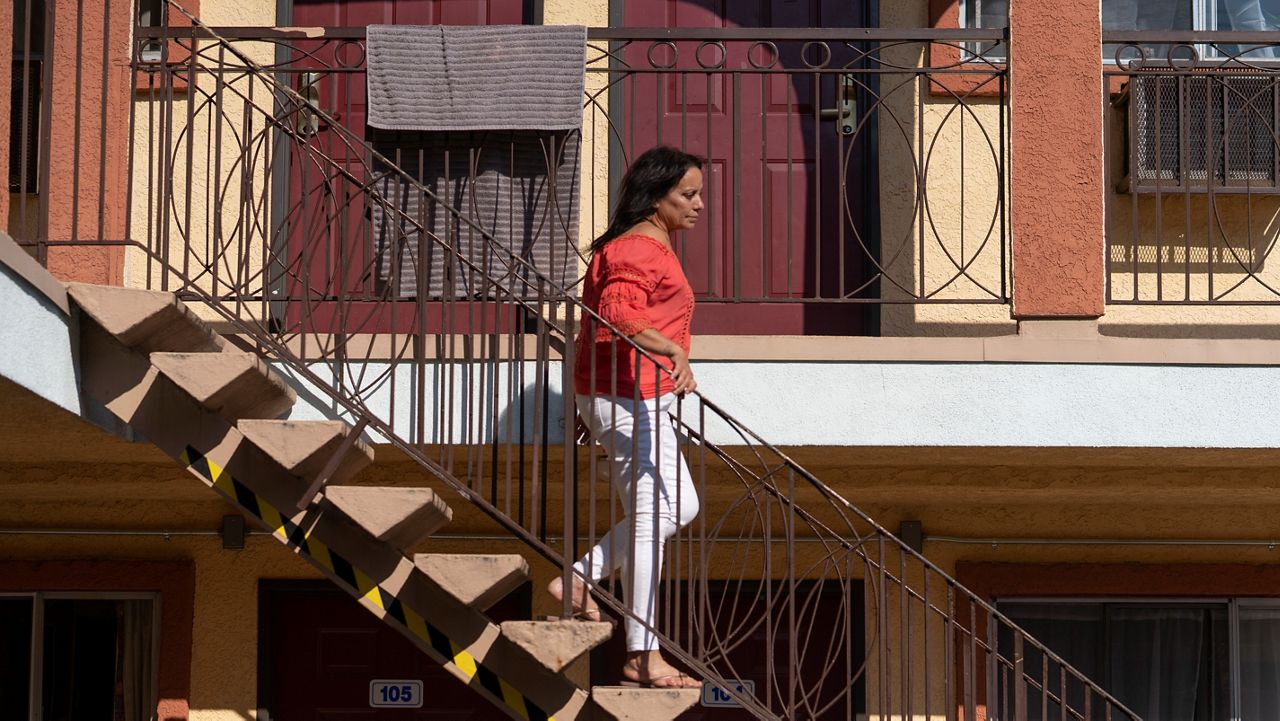 In this Wednesday, June 30, 2021, photo Veronica Perez walks down the steps outside her new home at the Mollie Mason Project Homekey site in Los Angeles. (AP Photo/Damian Dovarganes)