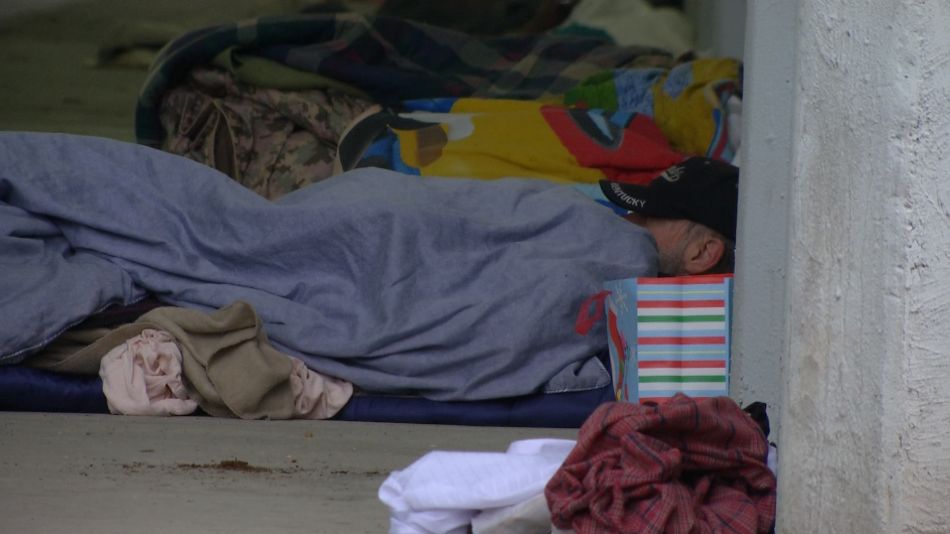 FILE photo of a homeless man sleeping on the ground. (Spectrum News)