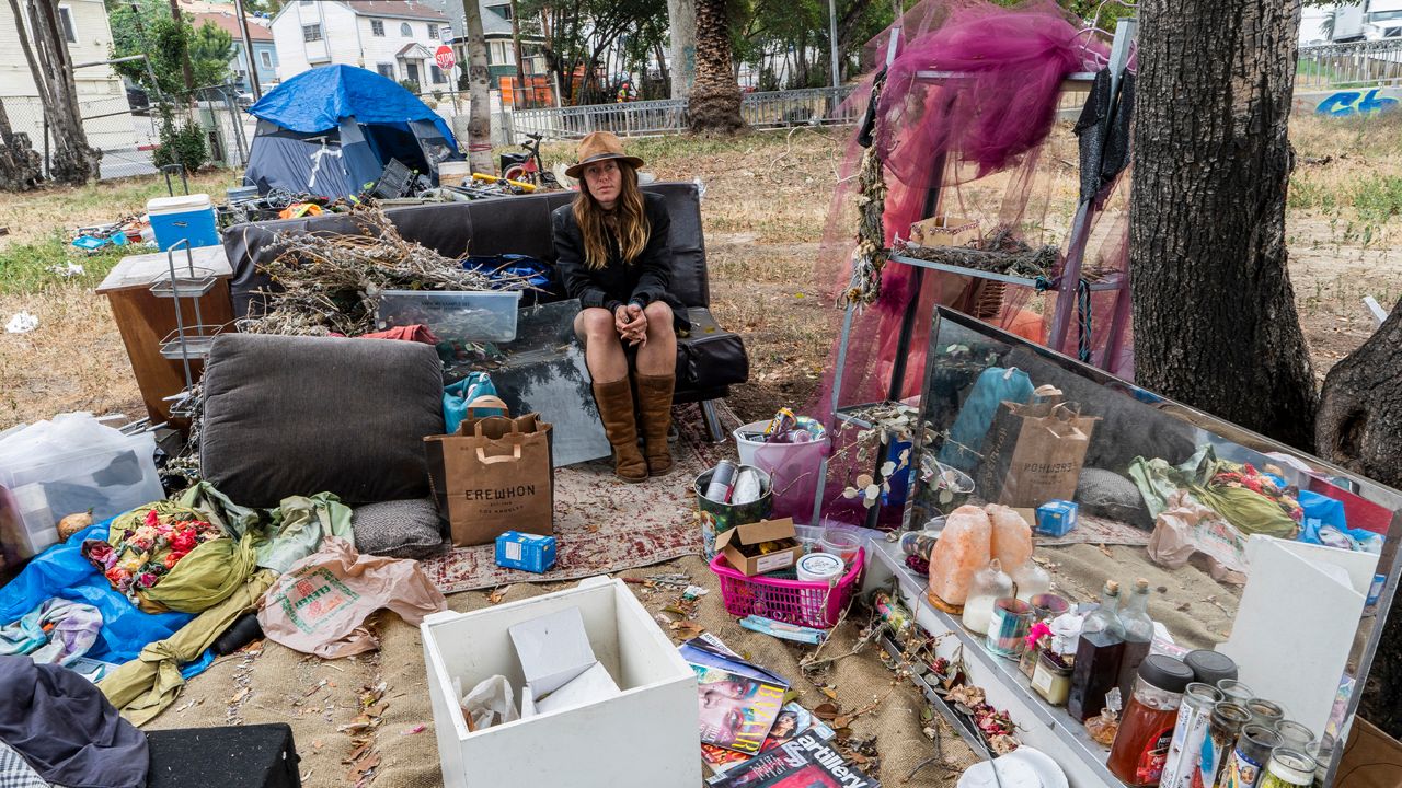 Dawn Woodward, 39, who is homeless and originally from Arizona, sits outdoors in a homeless camp on the side of the CA-101 highway in Echo Park neighborhood in Los Angeles Tuesday, May 11, 2021. (AP Photo/Damian Dovarganes)