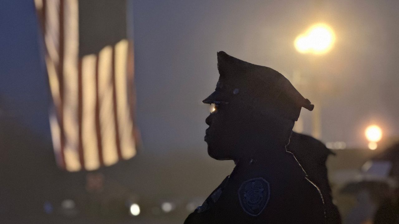 Officers await the arrival of a procession bearing Officer Michael Horan’s body from the medical examiner’s office in Raleigh to Hanes Lineberry Funeral Home in Greensboro. (Greensboro Police Department)