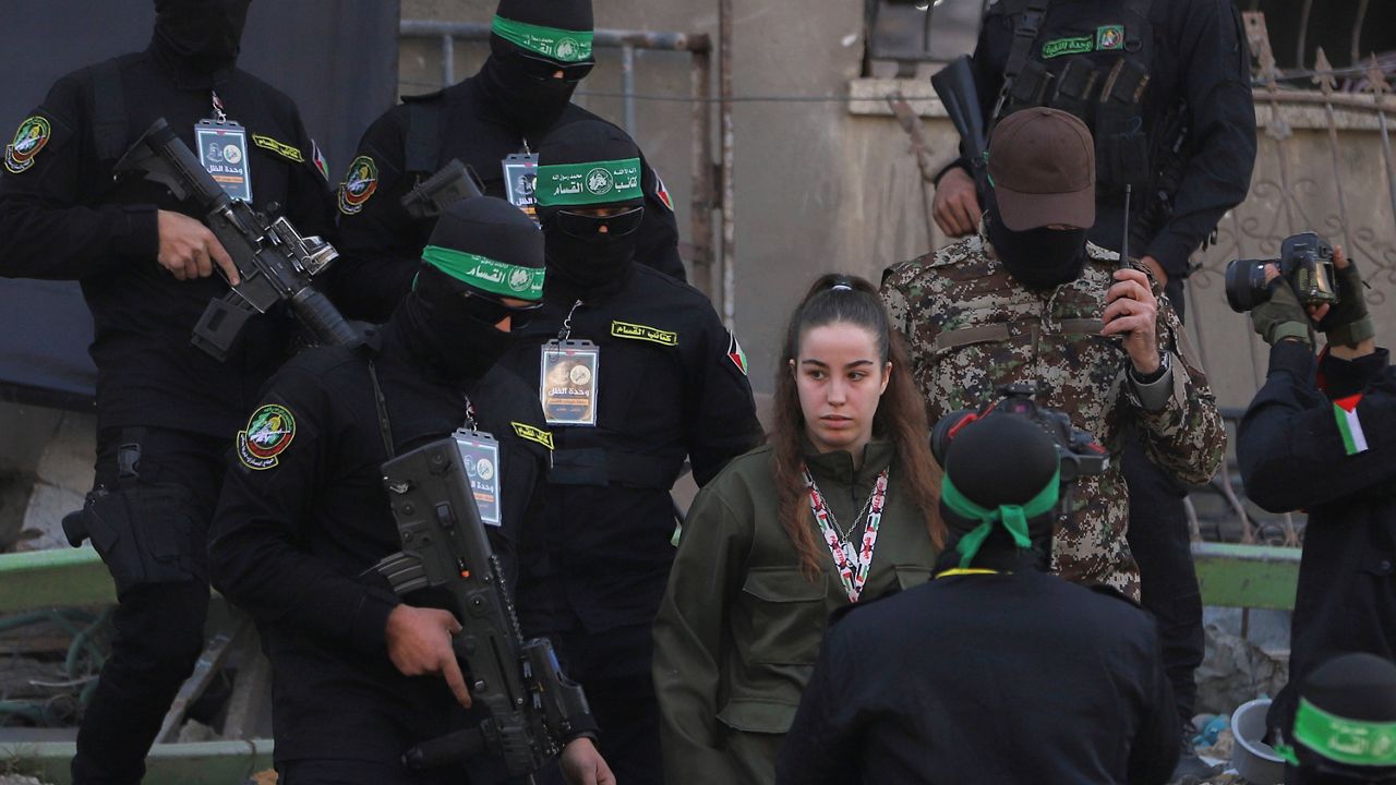 Israeli soldier Agam Berger walks next to masked Islamic Jihad militants as she is handed over to the Red Cross at the Jabalya refugee camp in Gaza City, Thursday Jan. 30, 2025.(AP Photo/Mohammed Hajjar)