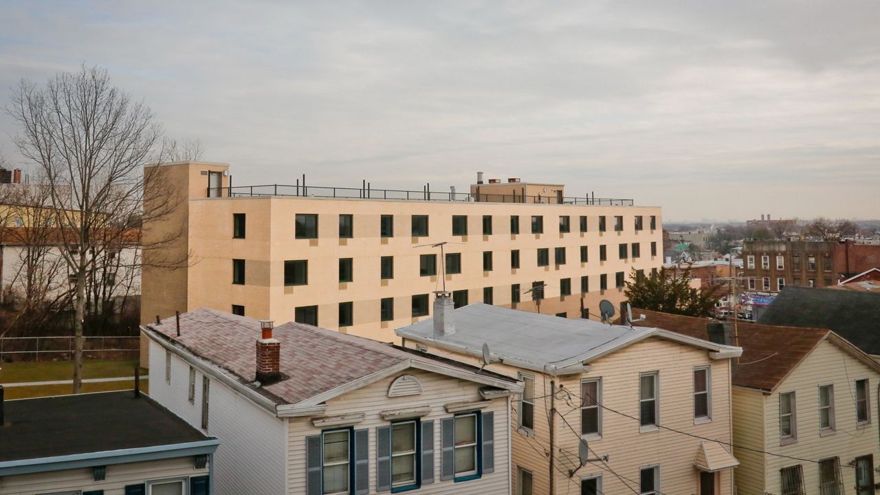 The new Cypress Hills Senior Residences building rise above residential homes, Tuesday Jan. 16, 2018, at in Brooklyn. (AP Photo/Bebeto Matthews)