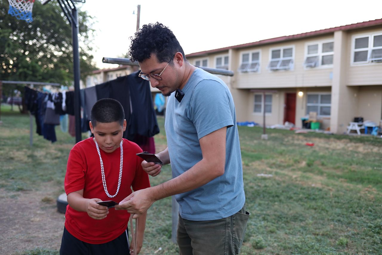 Francisco Cortés gives a child named Abraham a photo he took of him. (Spectrum News 1/Jose Arredondo)